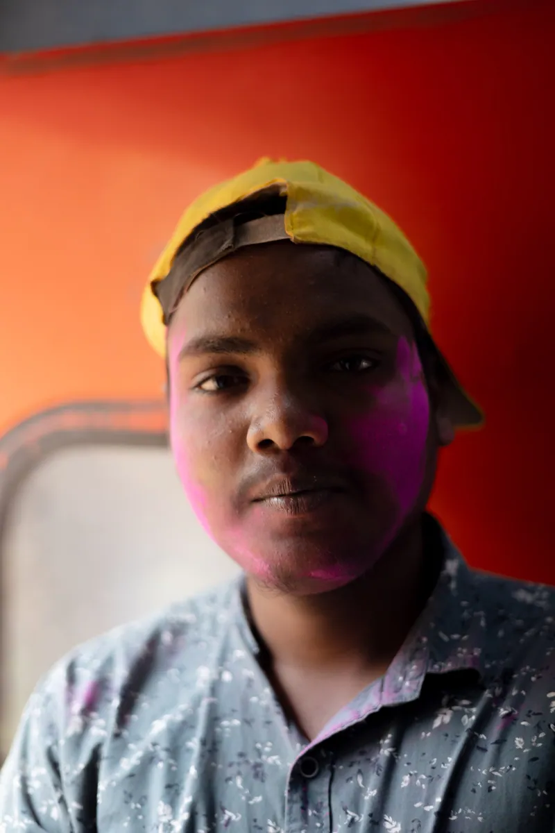 A boy on a train heading to the colourful Holi celebrations in India. Goa, India