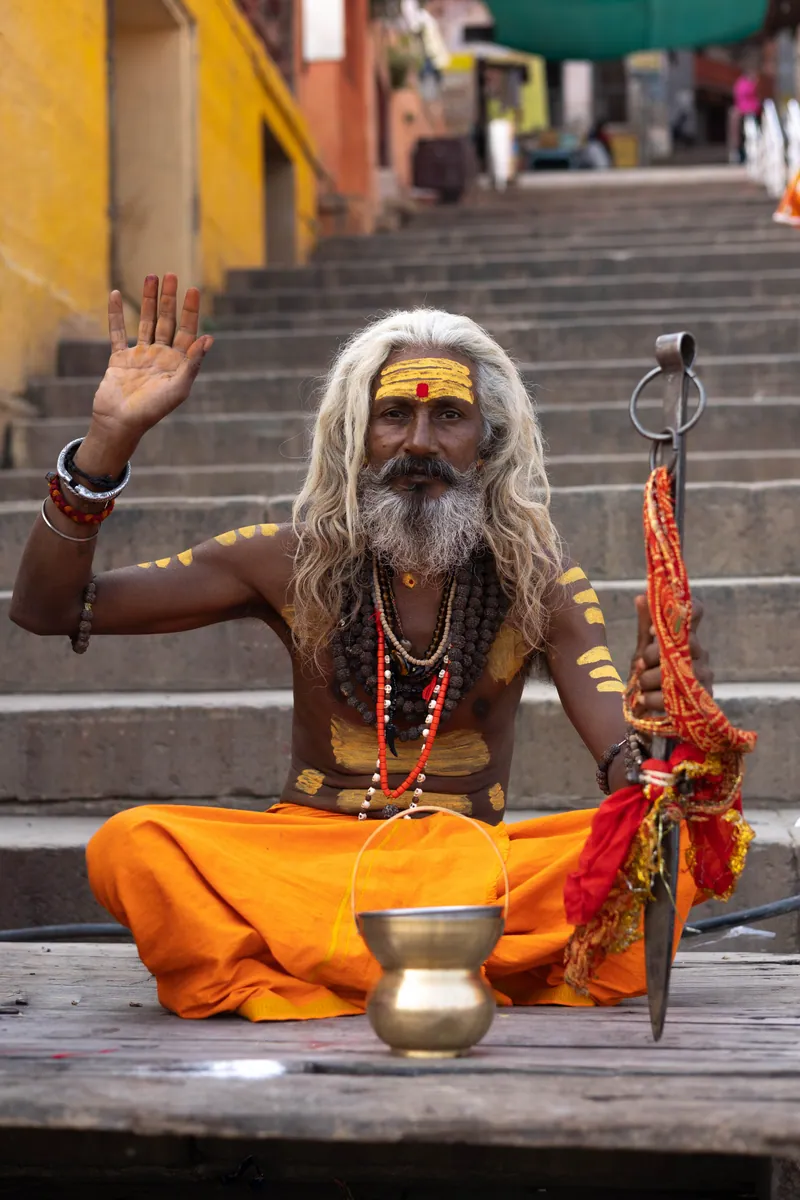 A Sadguru sitting at the foot of a Ghat on the water’s edge.